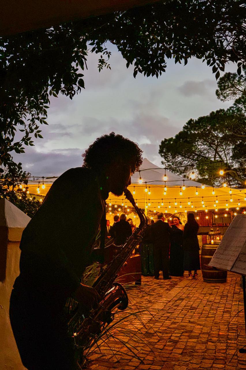 Live saxophonist playing at an outdoor wedding reception